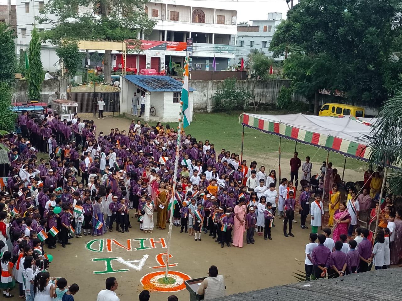 Students and staff gathered for a school celebration with the national flag